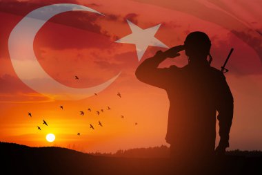Silhouette of soldier on a background of Turkey flag and the sunset or the sunrise. Concept of crisis of war and conflicts between nations. Greeting card for Turkish Armed Forces Day, Victory Day.