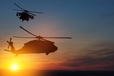 Gün batımının arka planında helikopter siluetleri. Gaziler Günü için tebrik kartı, Anma Günü, Hava Kuvvetleri Günü. ABD kutlaması.