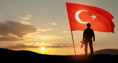 Gün batımında Türkiye bayrağı taşıyan asker silueti. Savaş krizi kavramı ve uluslar arasındaki siyasi çatışmalar. Türk Silahlı Kuvvetleri Günü için tebrik kartı, Zafer Günü.