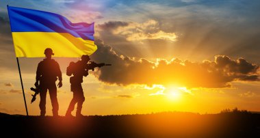 Flag of Ukraine with silhouette of soldier against the sunrise or sunset. Concept - armed forces of Ukraine. Relationship between Ukraine and Russia.