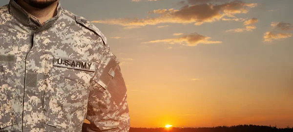 USA soldier in uniform on sunset sky background. Memorial Day or Veterans day concept.