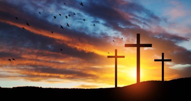 Christian cross on hill outdoors at sunrise. Resurrection of Jesus. Concept photo.