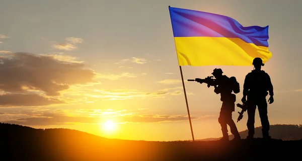 stock image Flag of Ukraine with silhouette of soldiers against the sunrise or sunset. Concept - armed forces of Ukraine. Relationship between Ukraine and Russia.