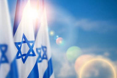 Israel flags with a star of David over cloudy sky background on sunset. Patriotic concept about Israel with national state symbols. Banner with place for text. clipart