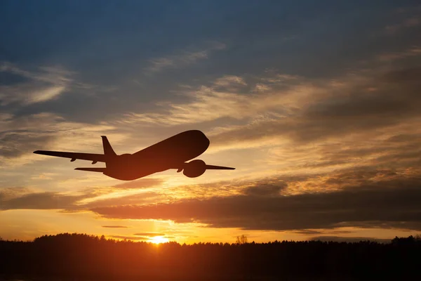 stock image Airplane taking off at the sunset sky. Silhouette of aircraft in the sky.