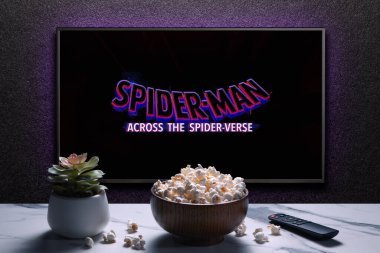 TV ekranında Örümcek Adam 'ın Örümcek Ayeti fragmanı ya da filmi oynanıyor. Uzaktan kumandalı televizyon, patlamış mısır kasesi ve ev bitkisi. Astana, Kazakistan - 15 Mayıs 2023.
