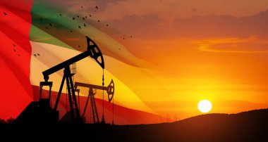 The change in oil prices caused by the war. Oil prices are rising because of the global crisis. Oil drilling derricks at desert oilfield with UAE flag. Crude oil production from the ground.