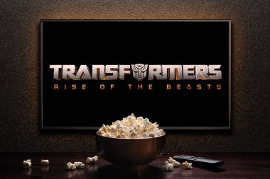 TV ekranında Transformers 'ın Rise of the Beast fragmanı ya da filmi oynanıyor. Uzaktan kumandalı televizyon ve patlamış mısır kasesi. Astana, Kazakistan - 15 Mayıs 2023.