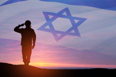 Silhouette of soldier saluting against the sunrise in the desert and Israel flag. Concept - armed forces of Israel.