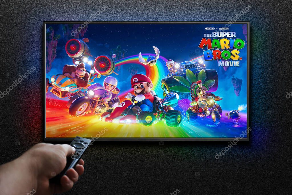 TV screen playing The Super Mario Bros. Movie trailer or movie. Man turns on TV with remote control. Astana, Kazakhstan - March 23, 2023.
