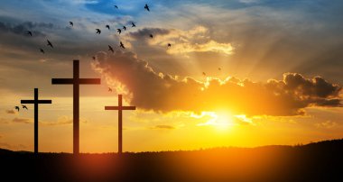 Christian cross on hill outdoors at sunrise. Resurrection of Jesus. Concept photo.