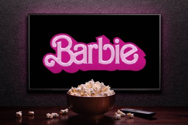 Televizyon ekranında Barbie karavanı ya da film oynanıyor. Uzaktan kumandalı televizyon ve patlamış mısır kasesi. Astana, Kazakistan - 2 Temmuz 2023.