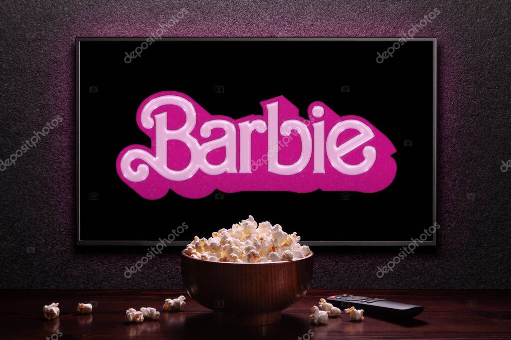 TV screen playing Barbie trailer or movie. TV with remote control and popcorn bowl. Astana, Kazakhstan - July 2, 2023.