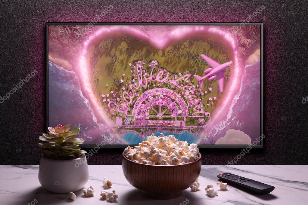 TV screen playing Barbie trailer or movie. TV with remote control, popcorn bowl and home plant. Astana, Kazakhstan - July 2, 2023.