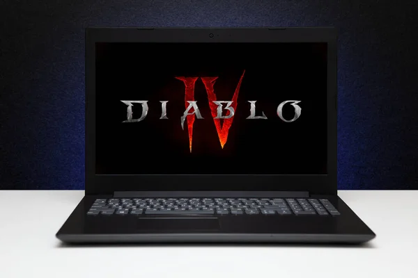 暗黑纹理墙壁上装有蓝光的屏幕笔记本电脑上的暗黑4游戏标识 毁灭4 是索尼最有名的角色扮演游戏系列之一 哈萨克斯坦阿斯塔纳 2023年7月2日 — 图库照片