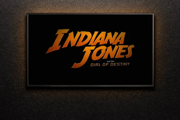TV ekranında Indiana Jones ve Kaderin Kaderi karavanı ya da filmi oynanıyor. Televizyon siyah desenli duvarda. Astana, Kazakistan - 15 Mayıs 2023.