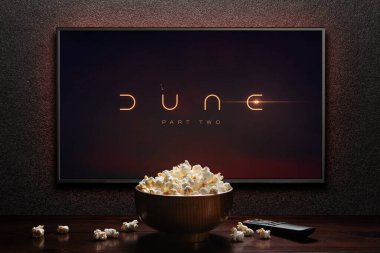 TV ekranında Dune Part Two fragmanı ya da film oynanıyor. Uzaktan kumandalı televizyon ve patlamış mısır kasesi. Astana, Kazakistan - 15 Mayıs 2023.