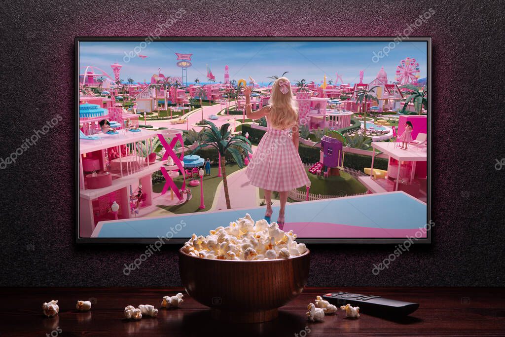 TV screen playing Barbie trailer or movie. TV with remote control and popcorn bowl. Astana, Kazakhstan - July 2, 2023.