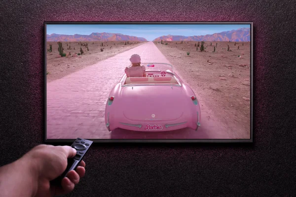 Телевизор Играет Барби Трейлер Фильм Человек Включает Телевизор Дистанционным Управлением — стоковое фото