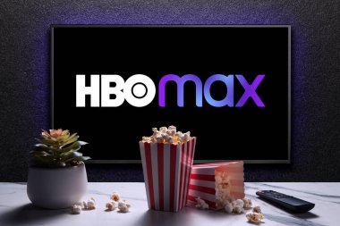 Max ya da HBO Max logosu TV 'de patlamış mısır kutuları, uzaktan kumanda ve masada ev bitkisi var. HBO Max, Amerika Birleşik Devletleri 'ne bağlı bir abonelik videosu. Astana, Kazakistan - 21 Temmuz 2023.