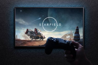 Televizyondaki Starfield maçı, elinde av alanı ile mavi ışıkla siyah desenli duvarda. Astana, Kazakistan - 31 Ağustos 2023.
