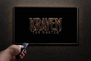 Avcı Kraven ya da TV ekranındaki film. Adam uzaktan kumandayla televizyonu açıyor. Astana, Kazakistan - 8 Eylül 2023.