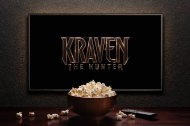 Avcı Kraven ya da TV ekranındaki film. Uzaktan kumandalı televizyon ve patlamış mısır kasesi. Astana, Kazakistan - 8 Eylül 2023.