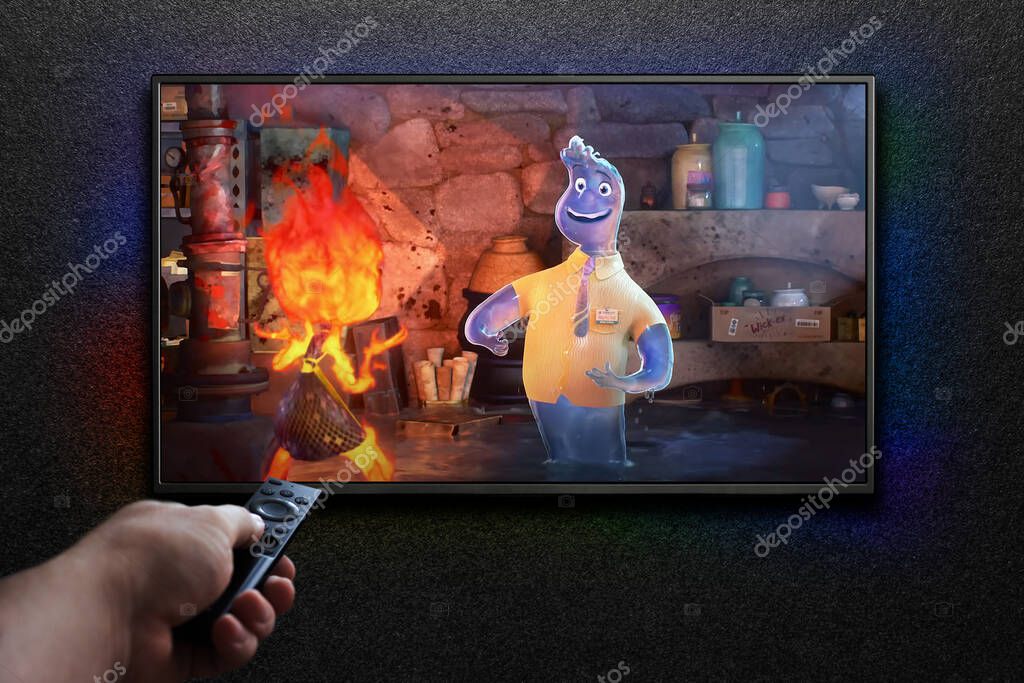 Elemental trailer or movie on TV screen. Man turns on TV with remote control. Astana, Kazakhstan - September 8, 2023.