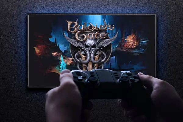 stock image Baldurs Gate 3 game on TV with gamepad in hand on black textured wall with blue light. Astana, Kazakhstan - August 31, 2023.