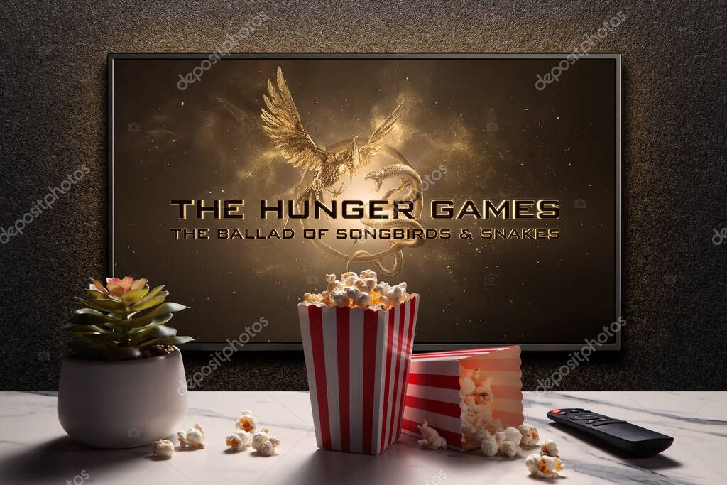 The Hunger Games The Ballad of Songbirds and Snakes trailer or movie on TV screen. TV with remote control, popcorn boxes and home plant. Astana, Kazakhstan - September 8, 2023.