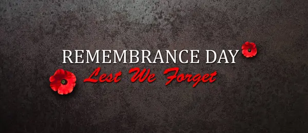 Remembrance Day Lest We Forget inscription with Poppy flower on rusty iron background. Decorative flower for Remembrance Day. Memorial Day. Veterans day.