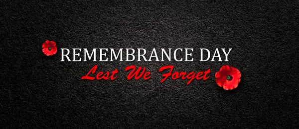 Remembrance Day Lest We Forget inscription with Poppy flower on black textured background. Decorative flower for Remembrance Day. Memorial Day. Veterans day.