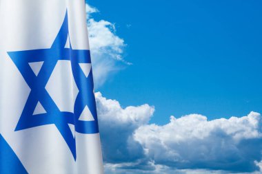 Israel flag with a star of David over cloudy sky background. Patriotic concept about Israel with national state symbols. Banner with place for text.