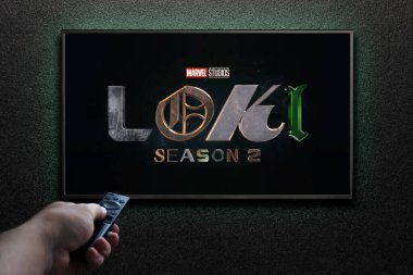Amerikan televizyon dizisi Loki fragmanı ya da TV ekranındaki film. Adam uzaktan kumandayla televizyonu açıyor. Astana, Kazakistan - 5 Ekim 2023.