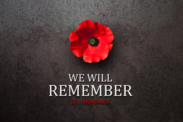 We Will Remember 11th November inscription with Poppy flower on rusty iron background. Decorative flower for Remembrance Day. Memorial Day. Veterans day.