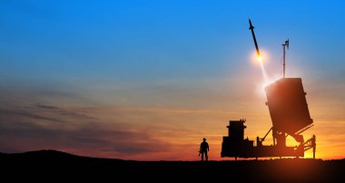 Israel's Iron Dome air defense missile launches. Silhouettes of soldier and Israel's Iron Dome air defense. The missiles are aimed at the sky at sunset. Missile defense. clipart