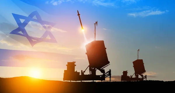 Israel\'s Iron Dome air defense missile launches. The missiles are aimed at the sky at sunset with Israel flag. Missile defense, a system of salvo fire.