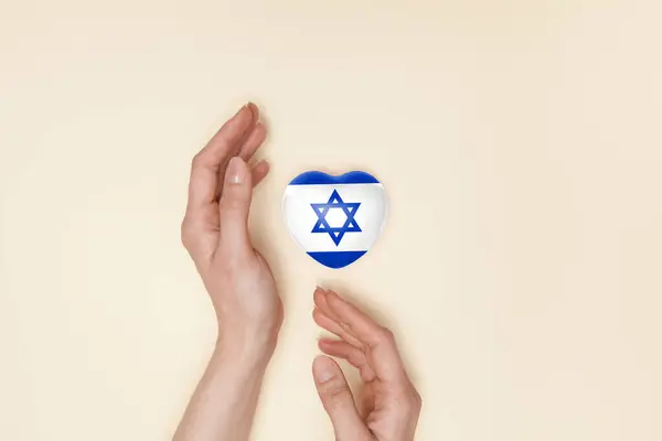 stock image Heart with print of Israel flag in female hands. Flat lay. Copy space.