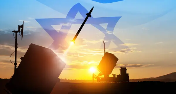 Closeup of Israel\'s Iron Dome air defense missile launches. The missiles are aimed at the sky at sunset with Israel flag. Missile defense, a system of salvo fire.