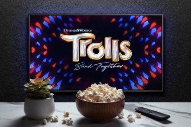 Troll Grubu karavanı ya da TV ekranında bir film. Uzaktan kumandalı televizyon, patlamış mısır kasesi ve ev bitkisi. Astana, Kazakistan - 15 Kasım 2023.