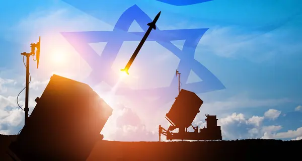 Closeup of Israel's Iron Dome air defense missile launches. The missiles are aimed at the sky at sunset with Israel flag. Missile defense, a system of salvo fire.