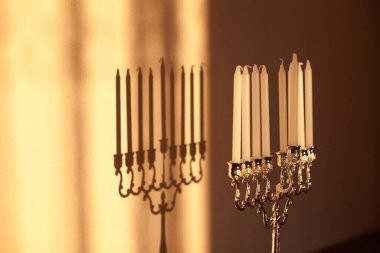 Hanuka menorası ya da gün batımında gün batımında Yahudi bayramı için Hanukkiah. Hanuka lambası, dokuz dallı şamdan ve duvarında gölgesi olan mumlar..