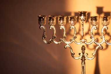 Hanuka menorası ya da gün batımında gün batımında Yahudi bayramı için Hanukkiah. Hanuka lambası, dokuz dallı şamdan. Duvarında gölgesi olan mumsuz..