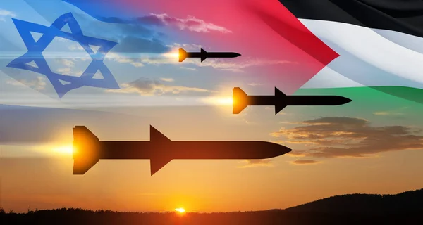 Confrontation between Palestine and Israel. Fired missiles fly to the target. Missiles at the sky at sunset with Palestine flag and Israel flag. Missile defense, a system of salvo fire.