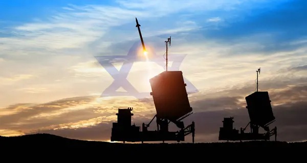 Israel\'s Iron Dome air defense missile launches. The missiles are aimed at the sky at sunset with Israel flag. Missile defense, a system of salvo fire.