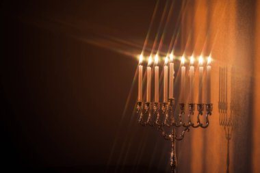 Hanuka menorası ya da gün batımında gün batımında Yahudi bayramı için Hanukkiah. Hanuka lambası, dokuz dallı şamdan, yıldız filtresiyle yanan mumlar..