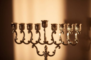 Hanuka menorası ya da gün batımında gün batımında Yahudi bayramı için Hanukkiah. Hanuka lambası, dokuz dallı şamdan. Duvarında gölgesi olan mumsuz..