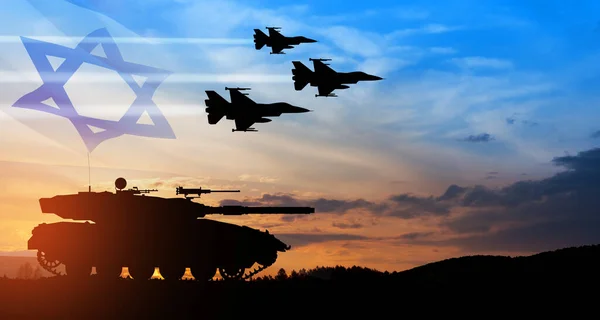 Silhouettes of army tank and fight planes on background of sunset with a transparent waving Israel flag. Military machinery. Independence day.