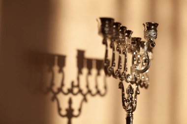 Hanuka menorası ya da gün batımında gün batımında Yahudi bayramı için gün ışığında Hanukkiah. Hanuka lambası, dokuz dallı şamdan. Duvarında gölgesi olan mumsuz..