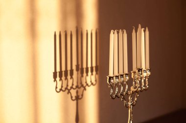 Hanuka menorası ya da gün batımında gün batımında Yahudi bayramı için Hanukkiah. Hanuka lambası, dokuz dallı şamdan ve duvarında gölgesi olan mumlar..